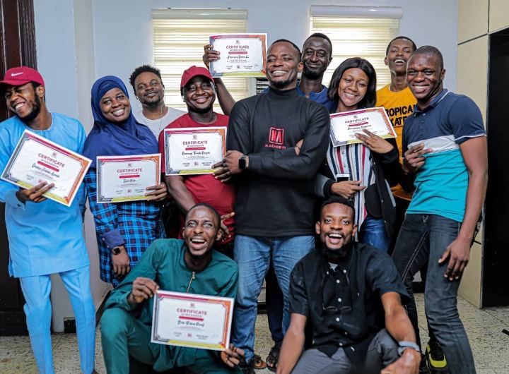 A graduating class holding their certificates