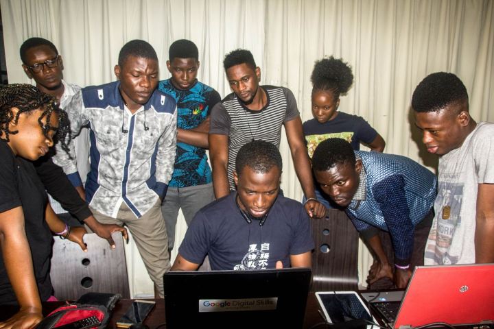 Students gathered around a laptop during class