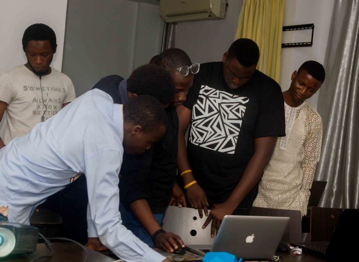 Nas helping students at their laptops