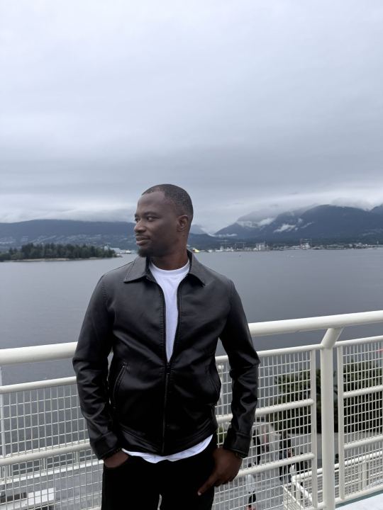 Nas in a leather jacket by the water