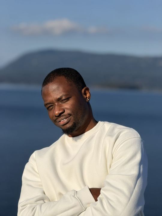 Nas in a white sweater by the sea